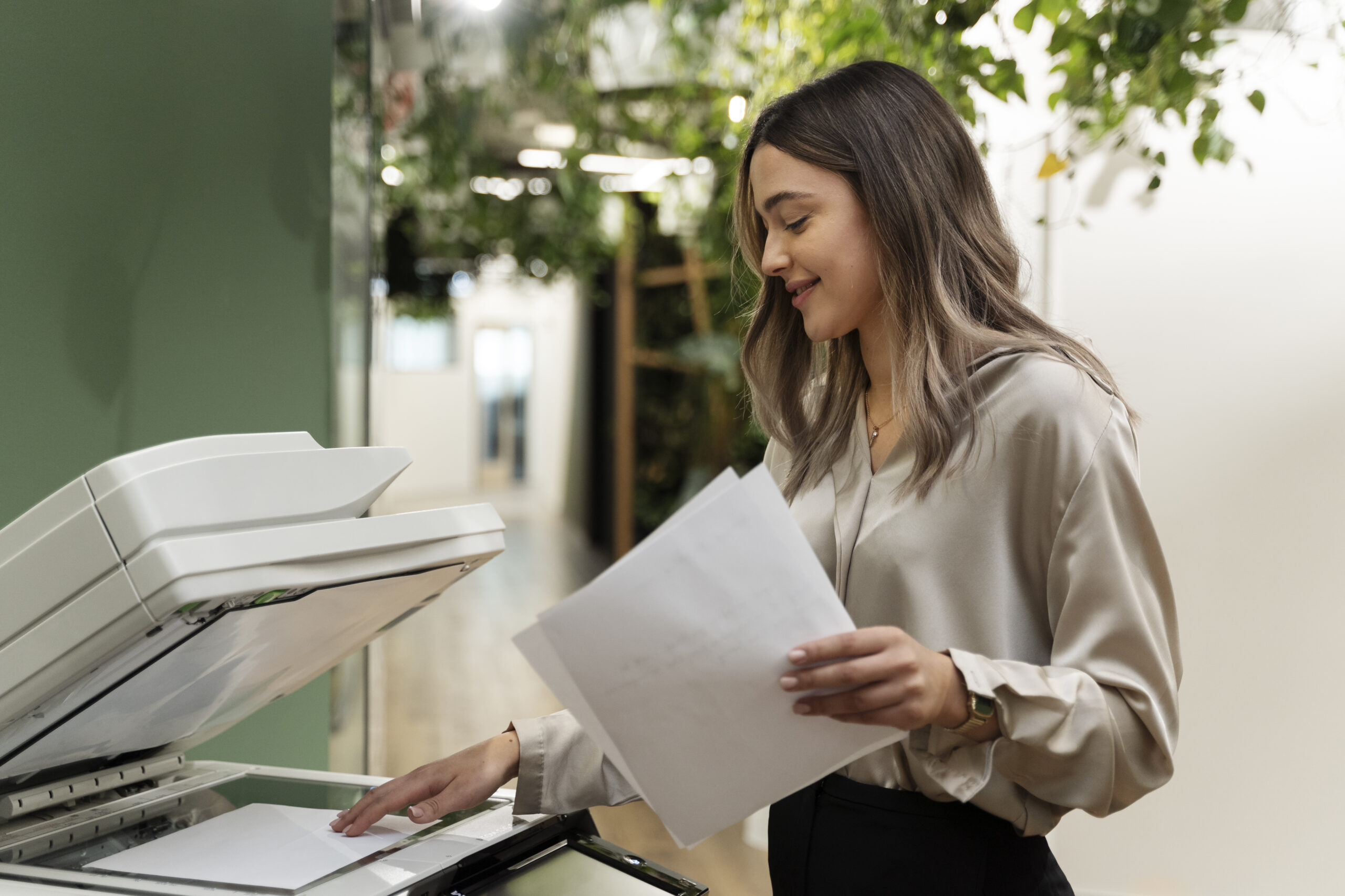 MacBook user collecting freshly printed pages