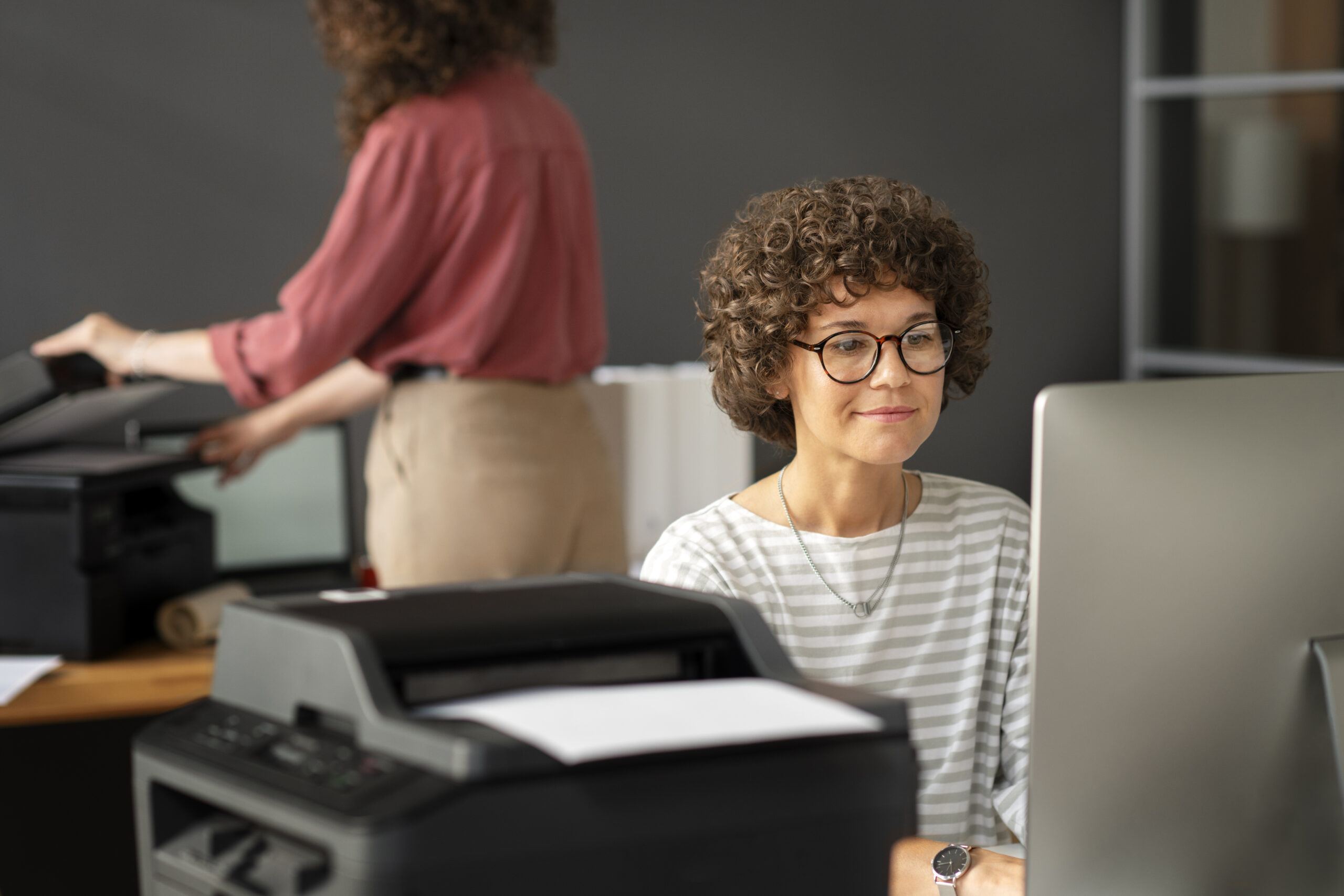 Two colleagues configuring a scanner on a Mac and a PC